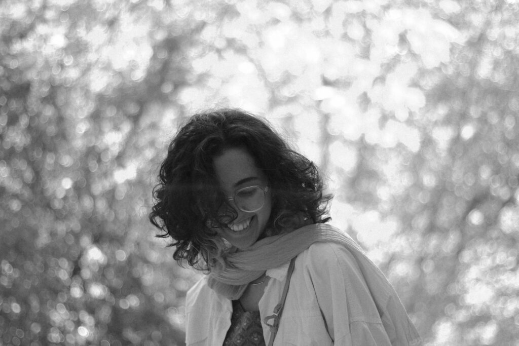 a black and white photo of a woman smiling
