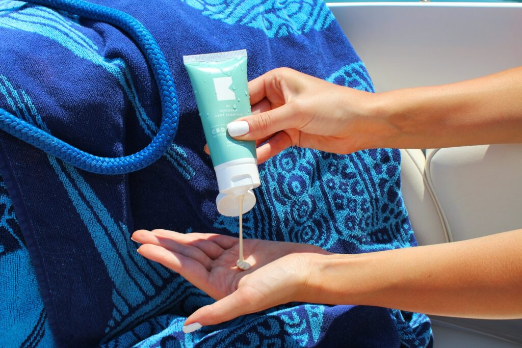 person holding white plastic tube bottle
