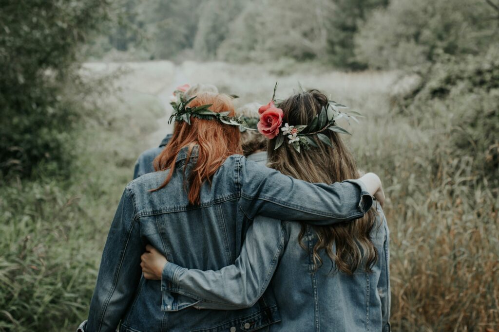 woman in blue denim jacket with red rose on ear

