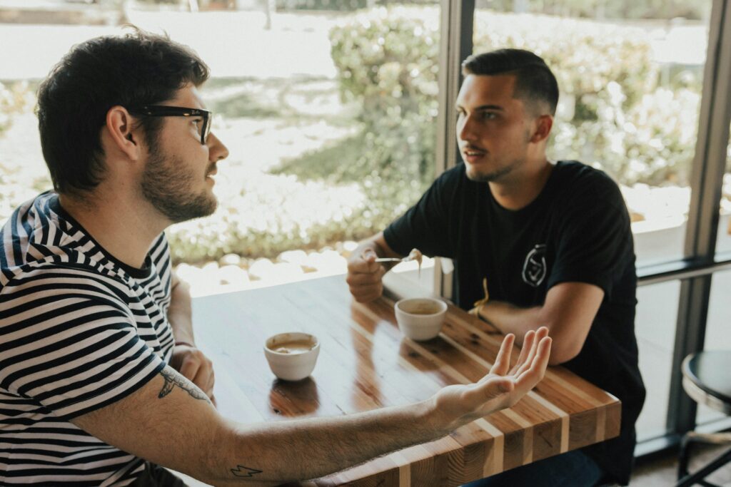 two men having conversation on table
