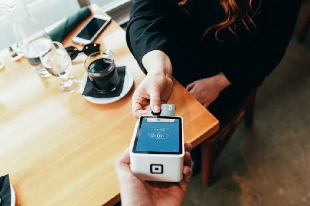 person holding credit card swipe machine
