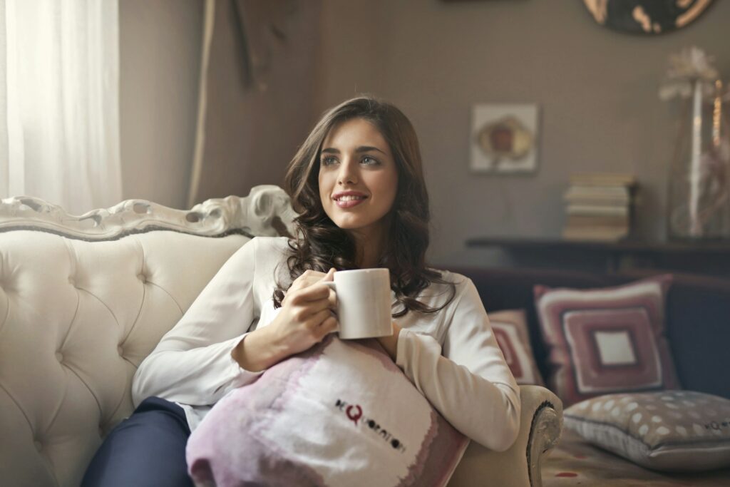 woman holding mug sitting on sofa
