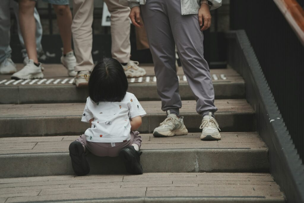 a little girl sitting on the steps of a building
