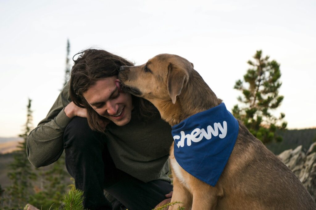 woman in black jacket holding brown short coated dog
