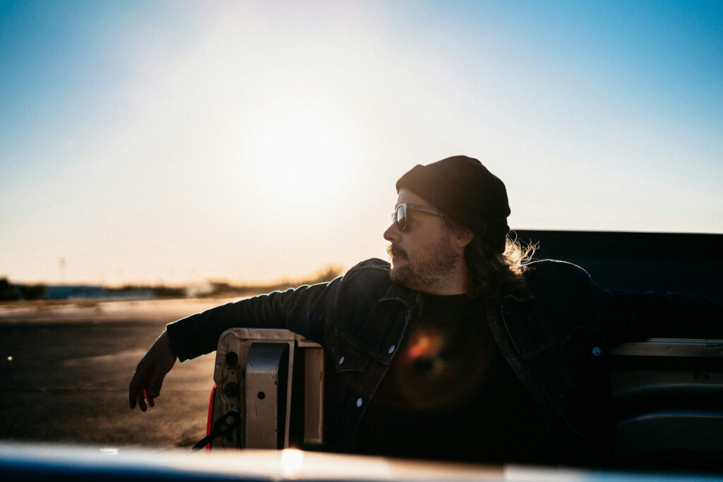 a man sitting in the back of a pickup truck

