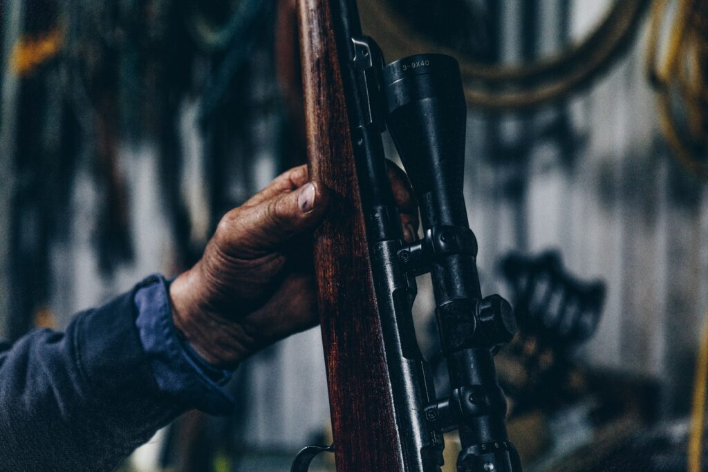 person holding brown and black hunting rifle
