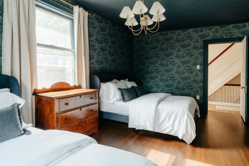 A bedroom with two beds and a dresser