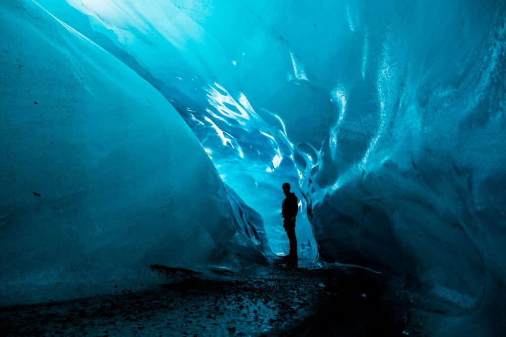 person standing in ice cave at daytime
