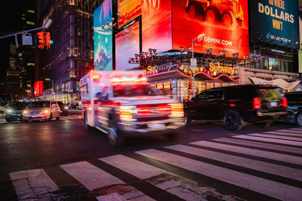 An ambulance races through busy times square.
