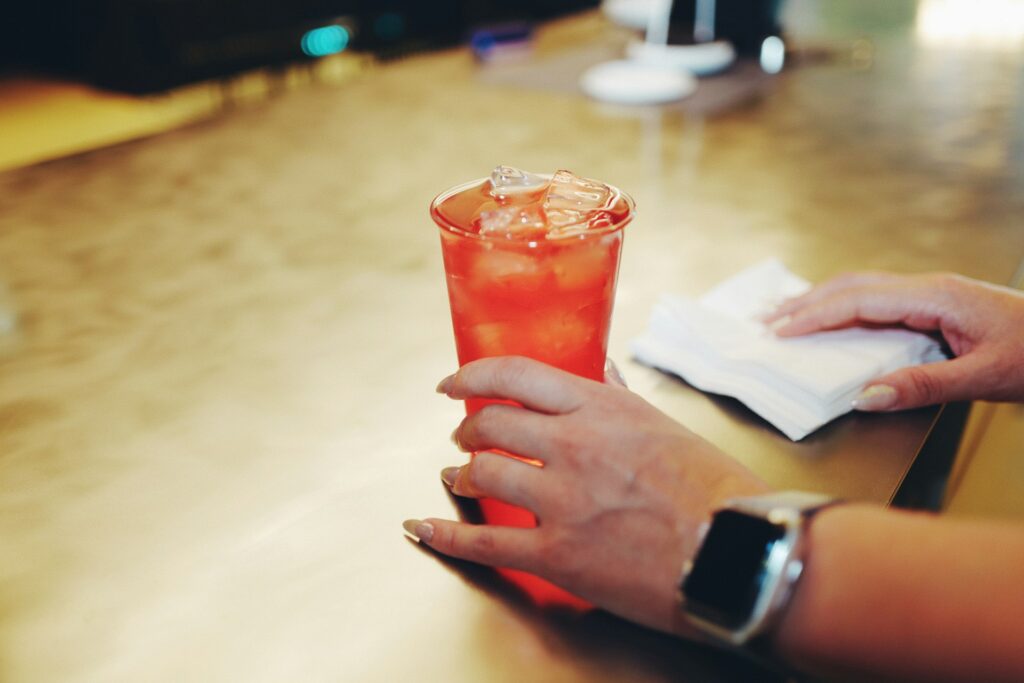 a close up of a person holding a drink

