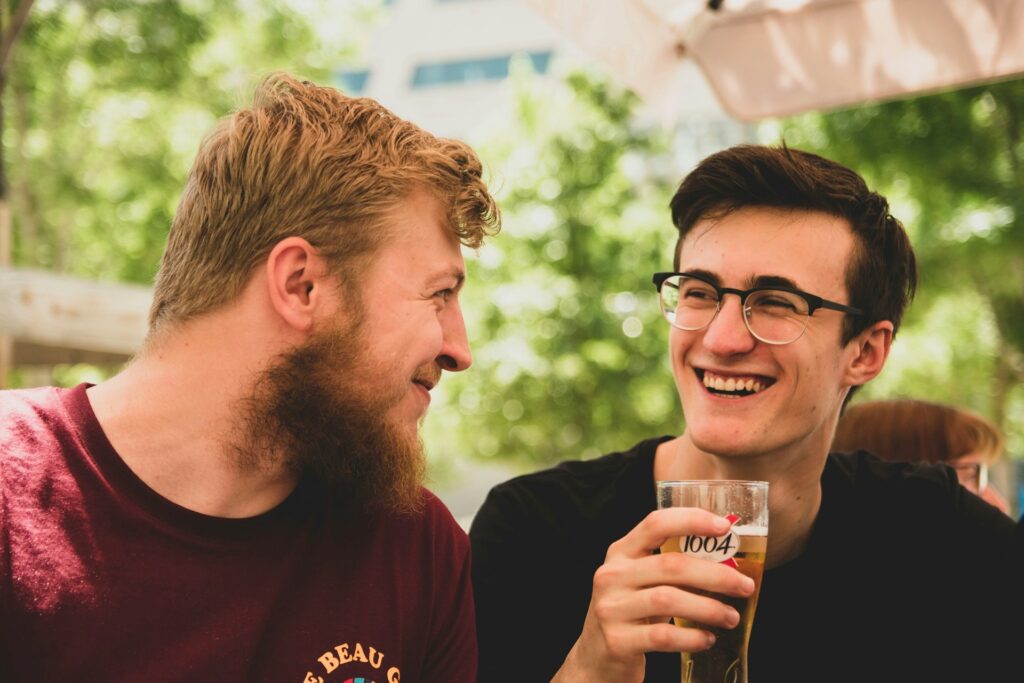 two men smiling near trees
