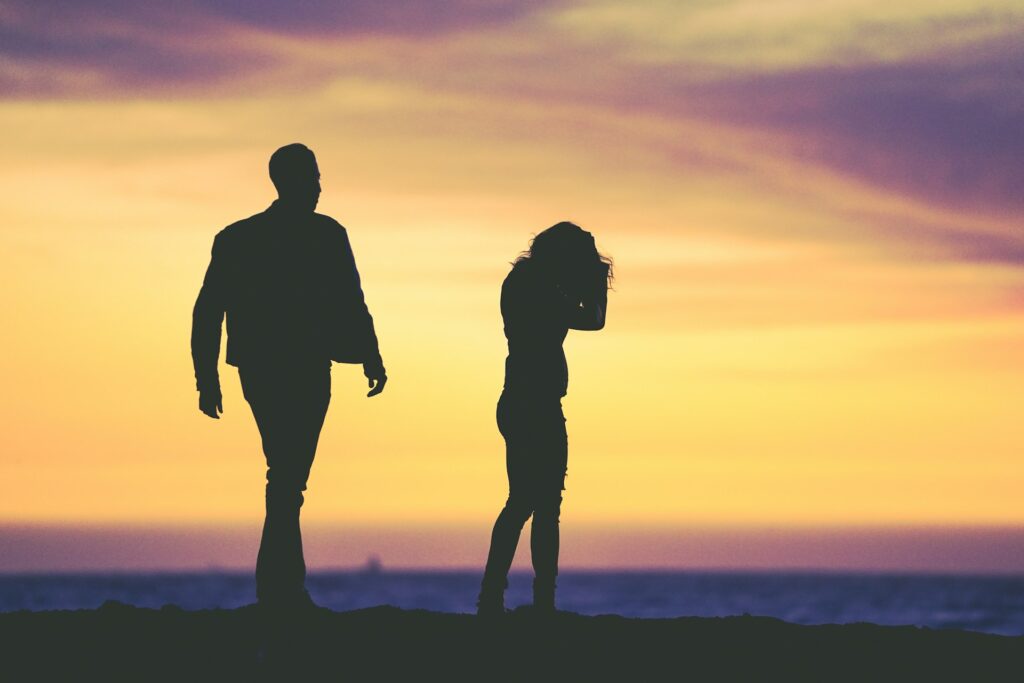 silhouette of man and woman under yellow sky
