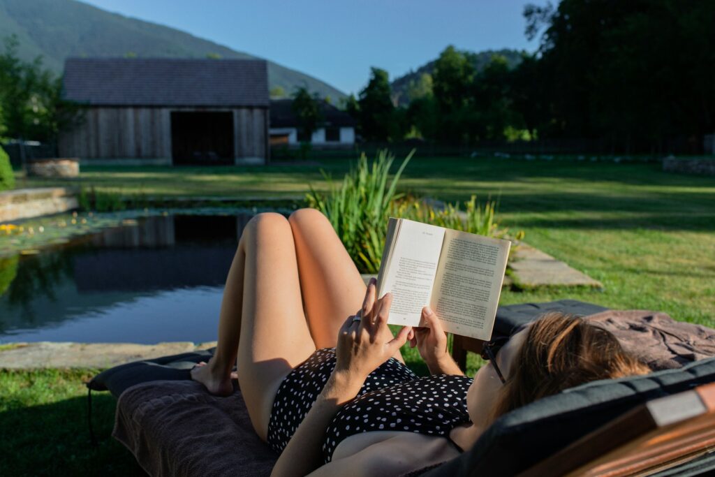 woman in black and white polka dot dress reading book
