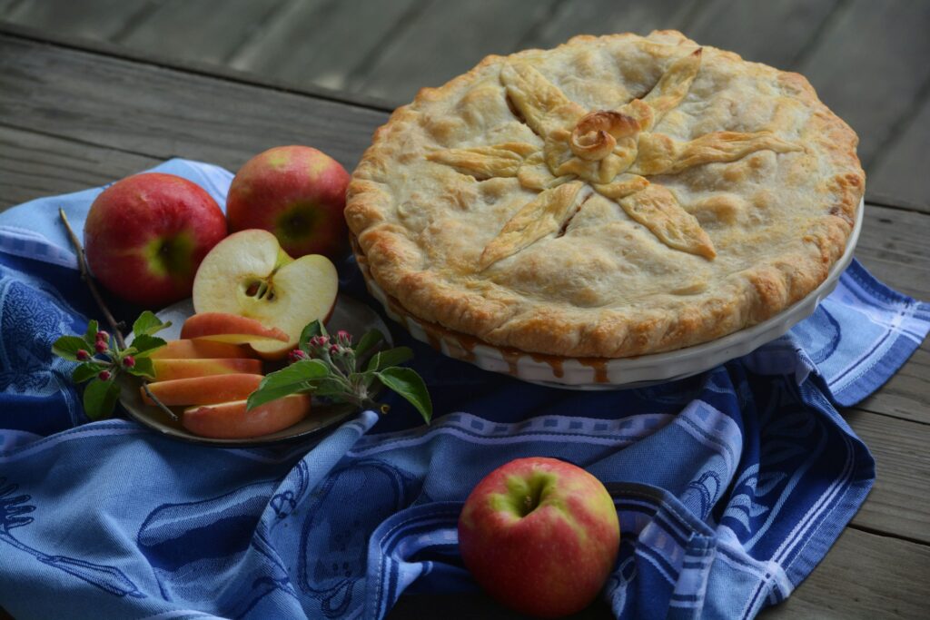a pie and some apples on a table
