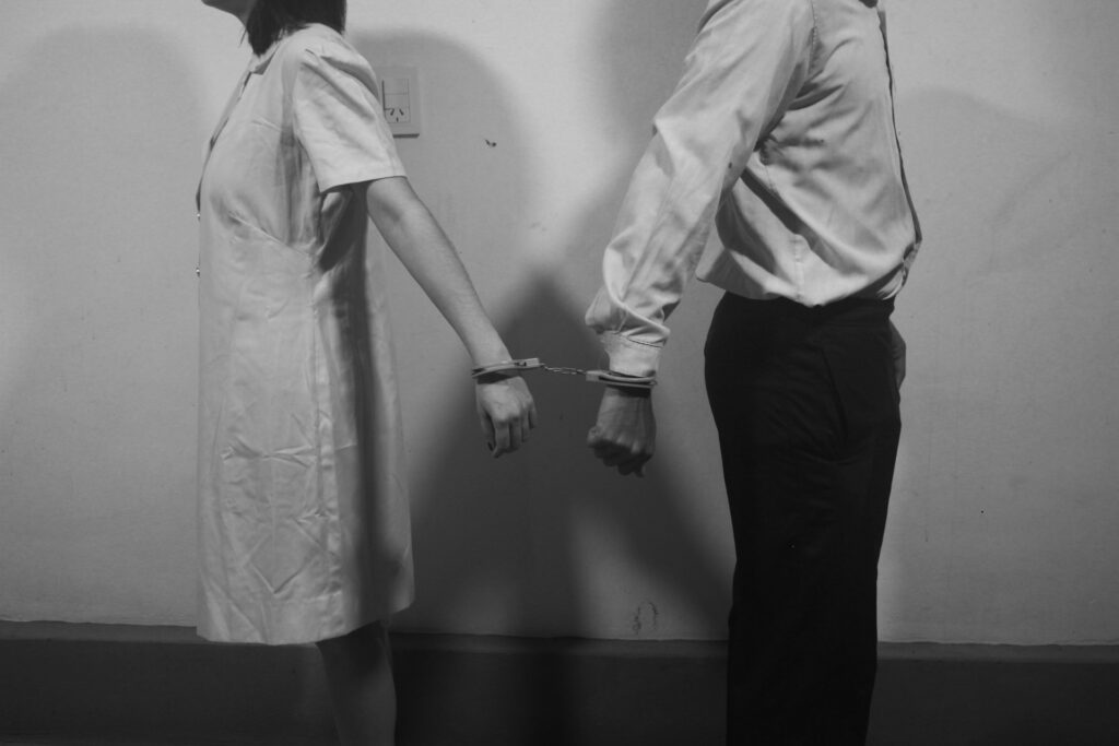man in white dress shirt and black pants standing beside wall
