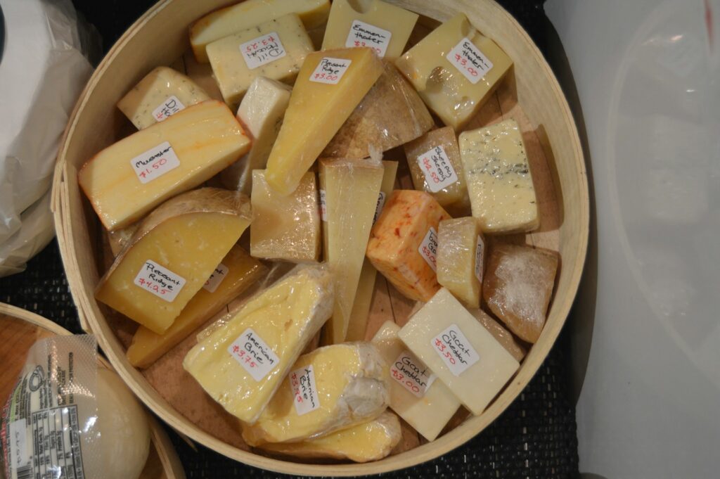 a wooden bowl filled with lots of cheese
