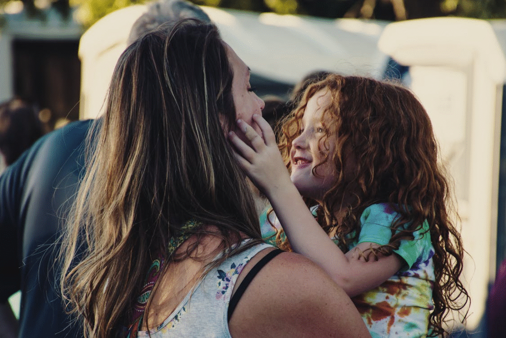 Woman Carrying Girl While Showing Smile

