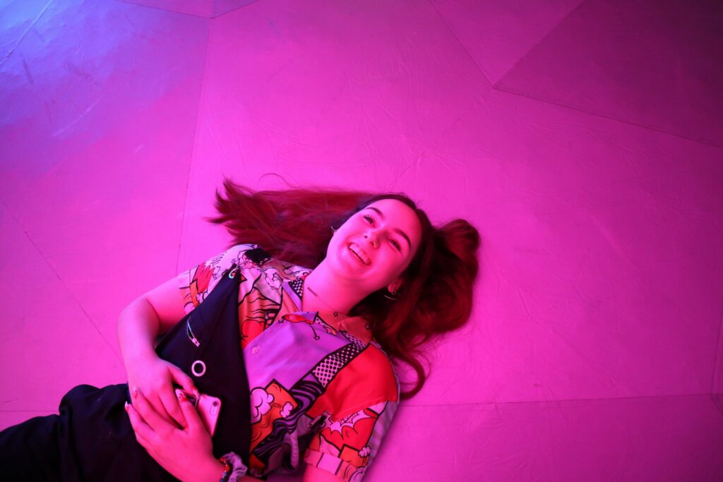 woman lies on pink floor

