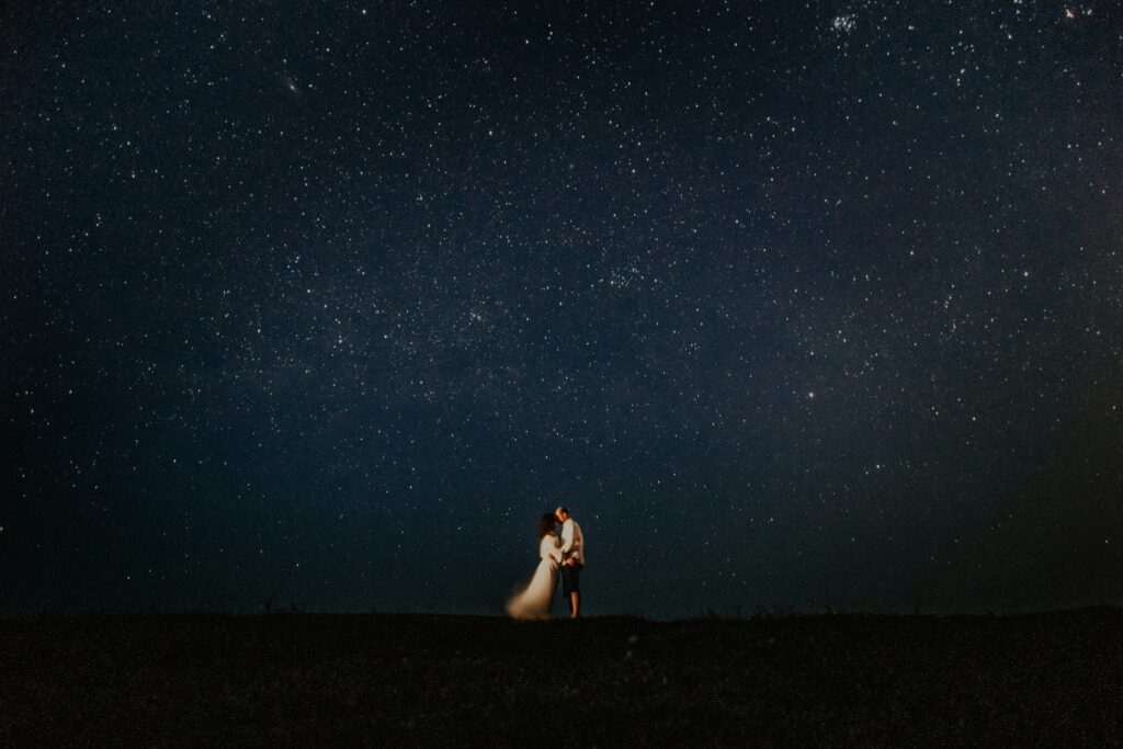 man and woman hugging at starry night

