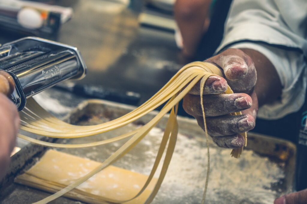 person sheeting dough
