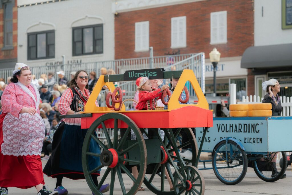 People participate in a parade, dressed in costumes.
