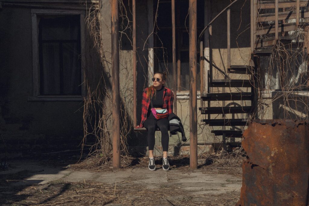 woman in red long sleeve shirt sitting on brown wooden bench