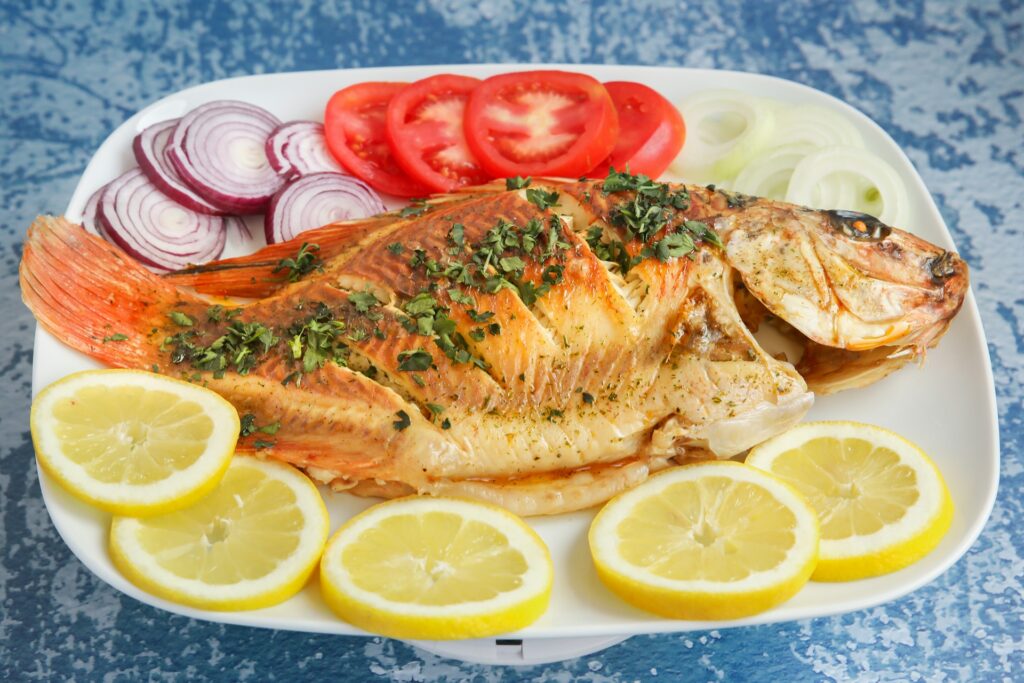 a plate of fish and lemons
