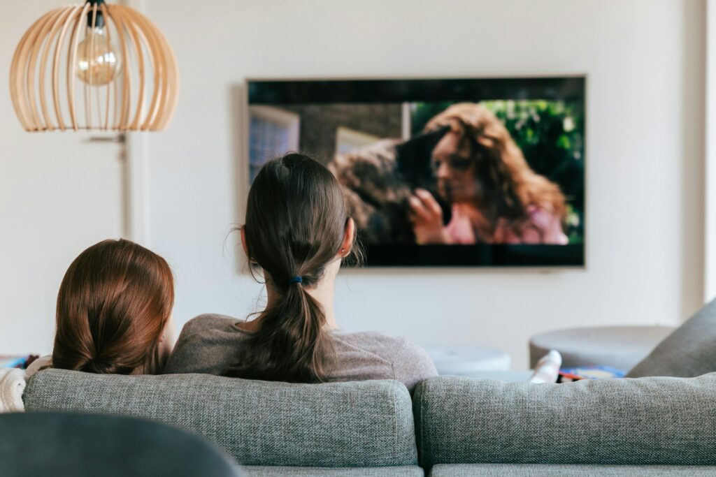 a couple of women sitting on top of a couch
