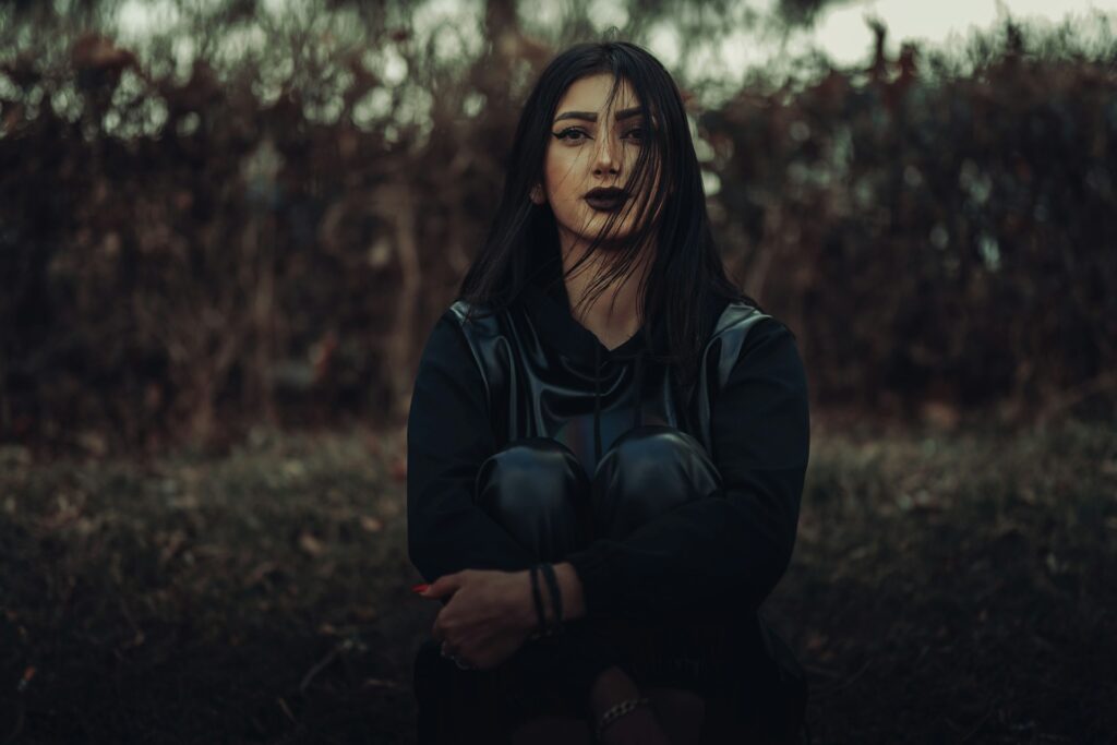 a woman with long hair and black gloves
