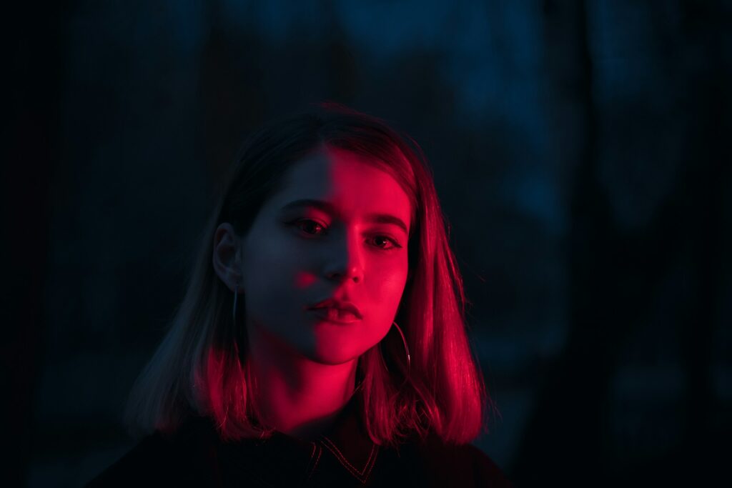 red lighting on woman's face at night
