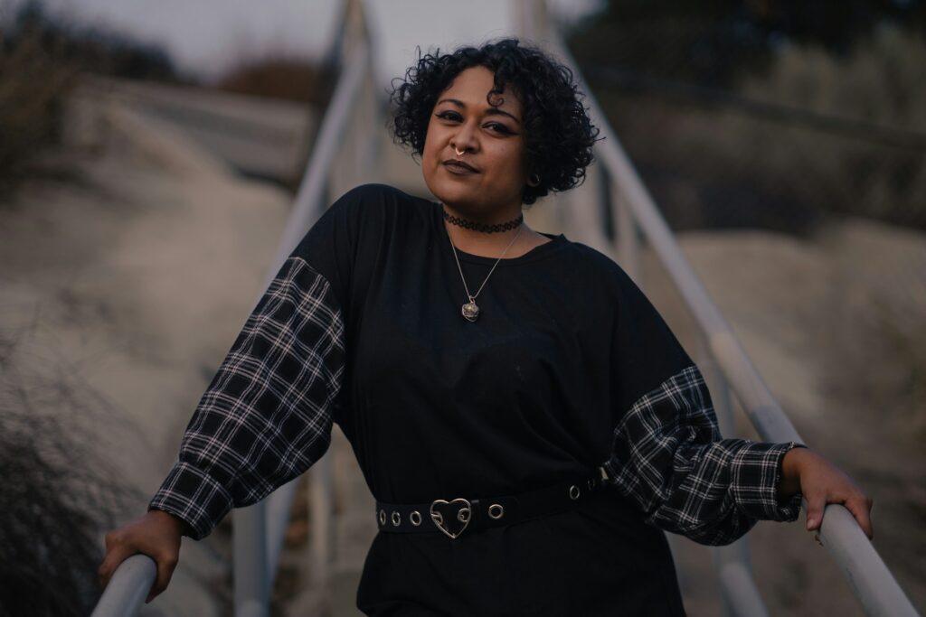 a woman standing on a bridge with her arms crossed
