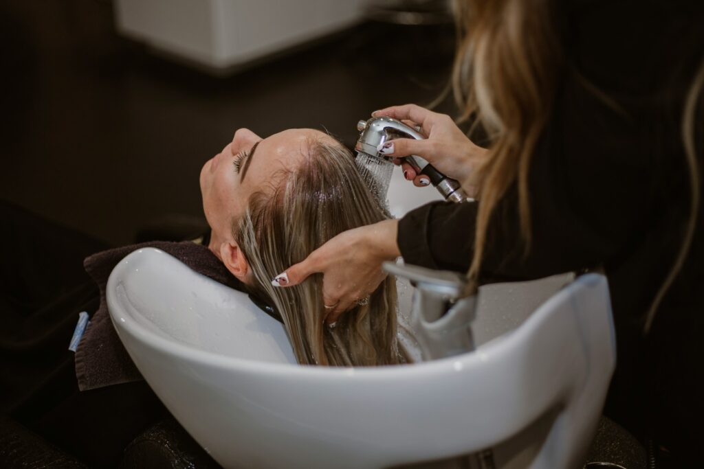 a woman getting her hair cut by a hair stylist
