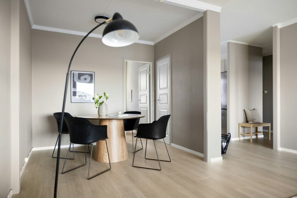 A room with a table, chairs and a lamp
