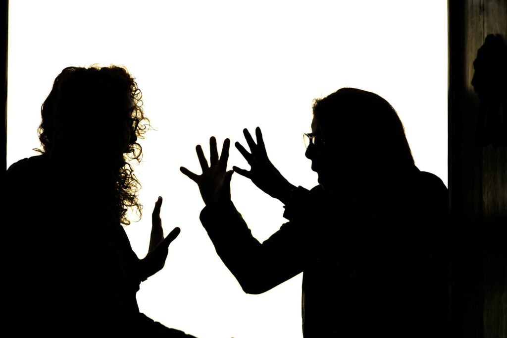 Silhouetted figures engage in a heated argument.
