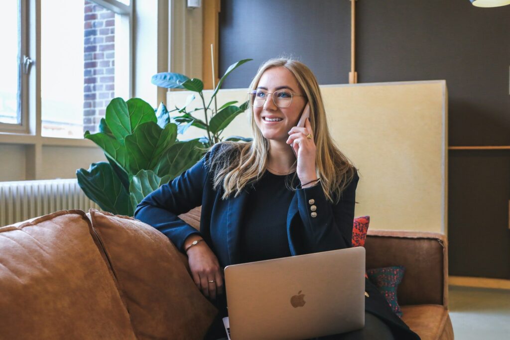 woman in blue long sleeve shirt using silver macbook
