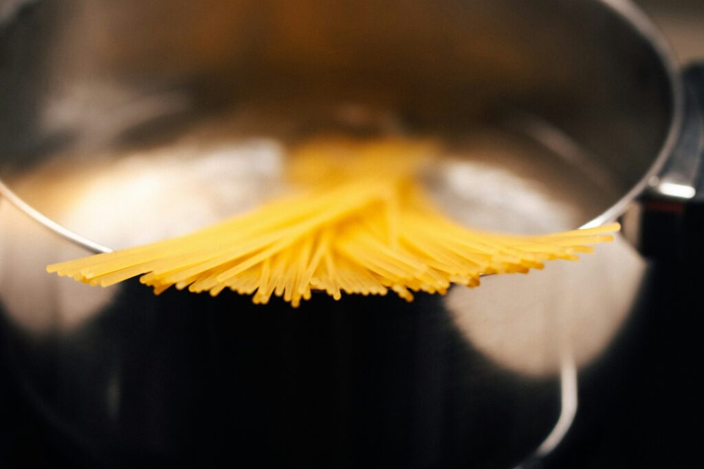a close up of a metal pot with noodles in it