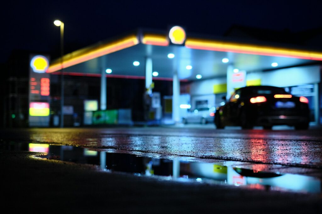 a car parked in front of a gas station at night
