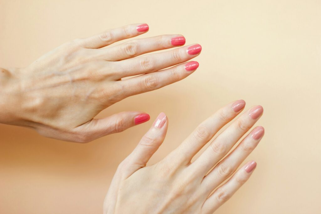 A woman's hands with red nail polish on them
