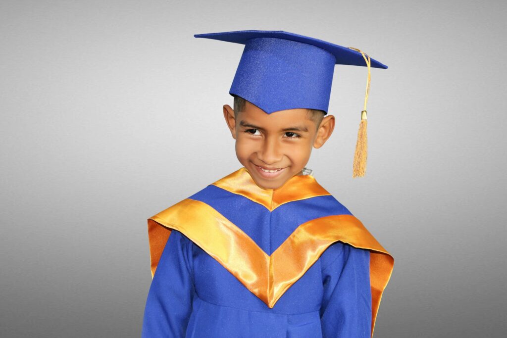 a young boy in a blue graduation gown
