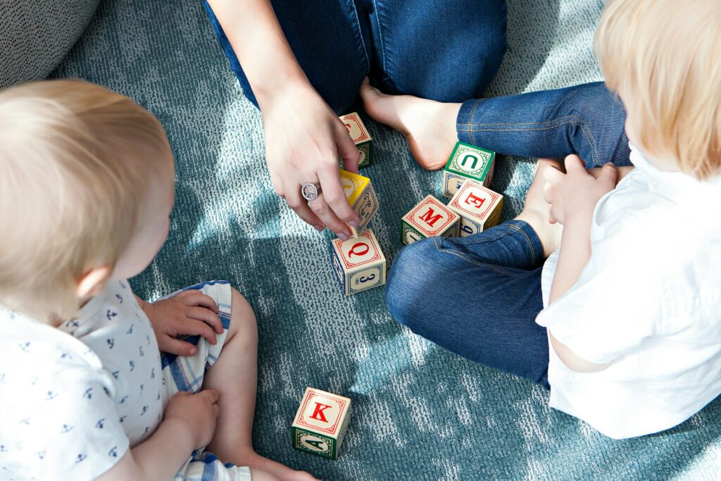 two toddler playing letter cubes

