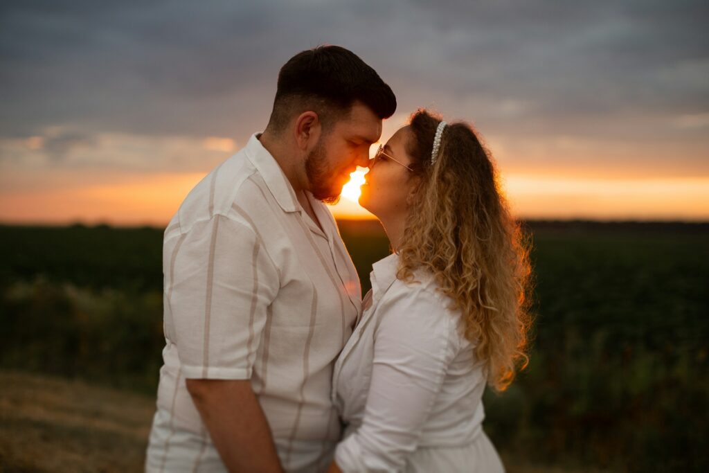 A loving couple shares a romantic sunset moment.