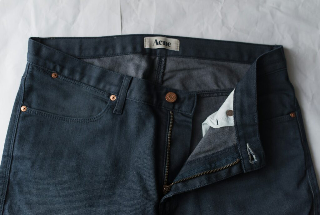 blue denim jeans on white textile

