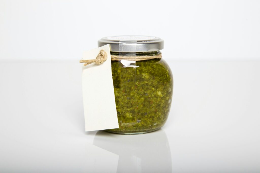 clear glass jar with green kush inside
