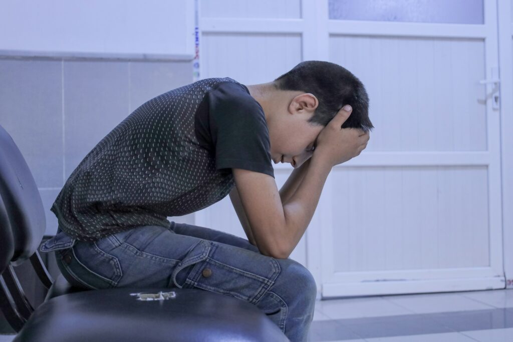 A man sitting on a chair with his head in his hands
