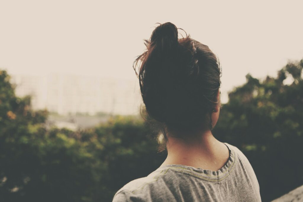 focus photography of woman facing trees
