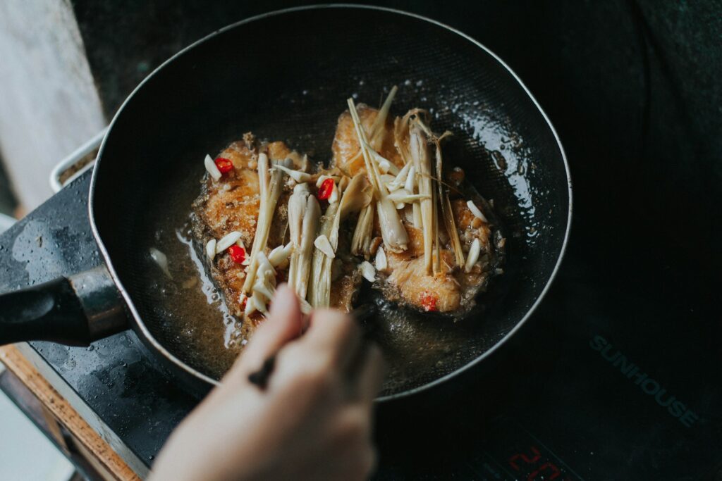 person holding black ceramic bowl with food
