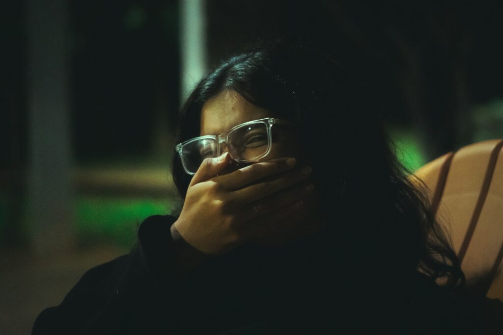 A woman wearing glasses is talking on a cell phone