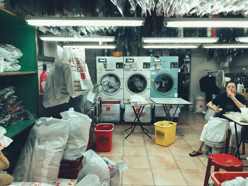 a woman sitting in front of a washing machine
