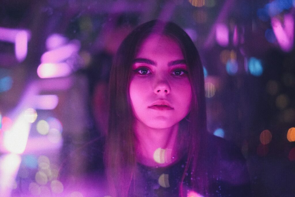 a woman standing in front of a purple light
