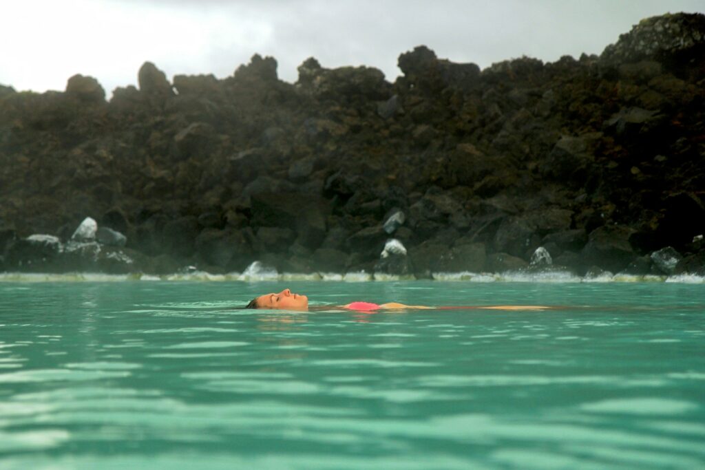 people swimming in the lake during daytime
